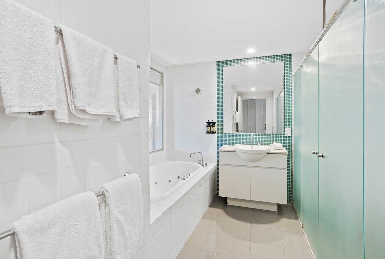 A modern bathroom with a bathtub, a sink, and a mirror.