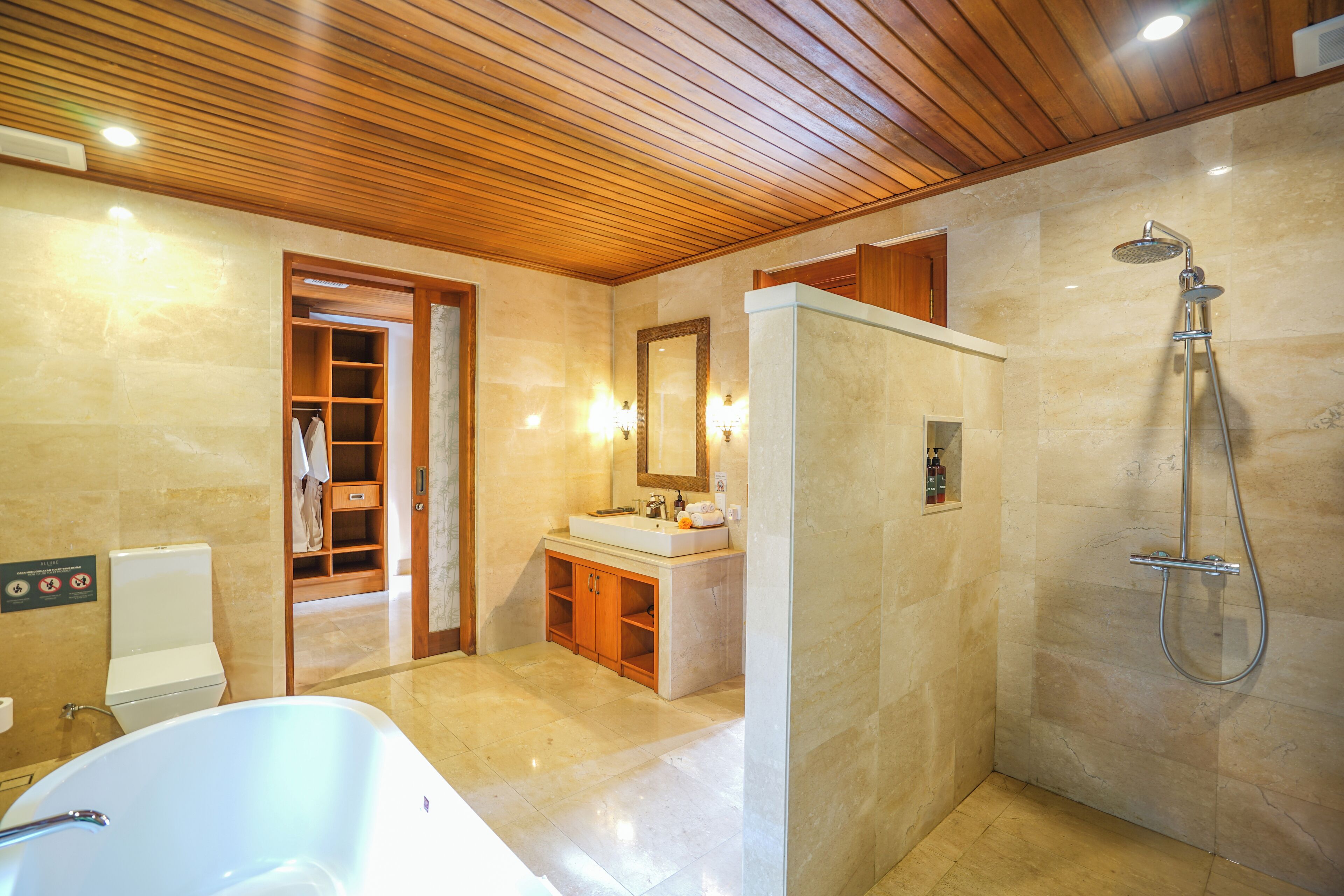A modern bathroom with a wooden ceiling, a large bathtub, a shower, and a vanity with a mirror.