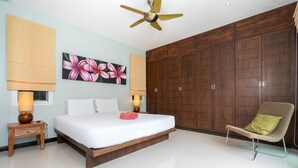A bedroom with a large bed, wooden wardrobe, and a ceiling fan. - Tropical 3BR Pool Villa Morning Forest  (Rawai)