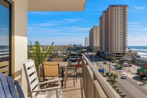 A balcony with a view of the ocean, a tall building, and a street with cars and a bus. - Origin 635 + 637: Incredible Views + Ultimate Privacy (Panama City Beach)