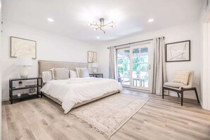 A bedroom with a large bed, bedside tables, a rug, and a chair.