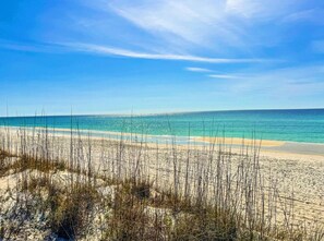 Een strand met heldere luchten en rustig water.