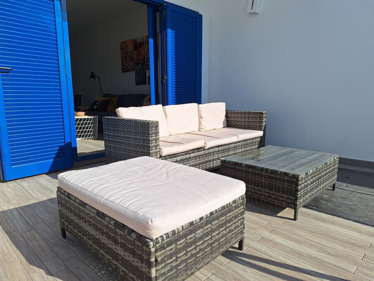 Un patio con mobiliario de mimbre, incluyendo dos sofás y una mesa de centro.