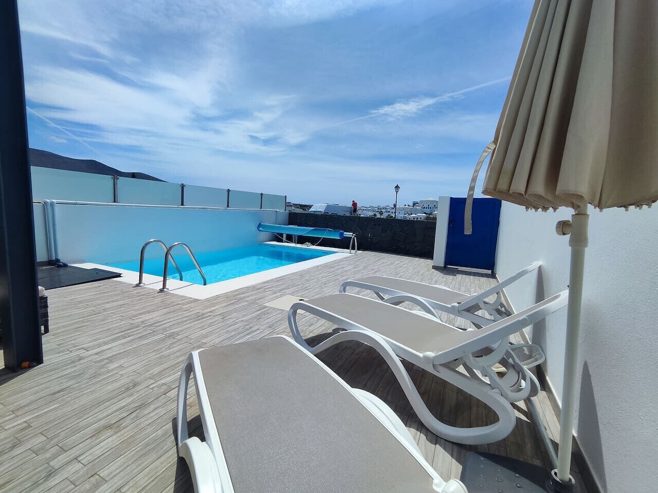 A pool area with lounge chairs and a diving board.