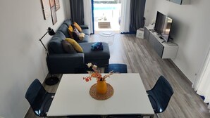 A modern living room with a sofa, a coffee table, and a TV. - Casa del Sol, heated pool quiet place (Playa Blanca)