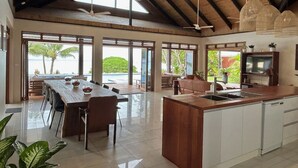 A spacious kitchen with a large island, modern appliances, and a view of the outdoors. - Mokusiga Villas Tolu - Private Beachfront Villa (Korolevu)