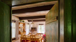 A wooden dining room with a table and chairs, a chandelier, and a window with curtains. - Beautiful private villa for 6 guests with WIFI, TV and terrace (Jablonec Nad Nisou)