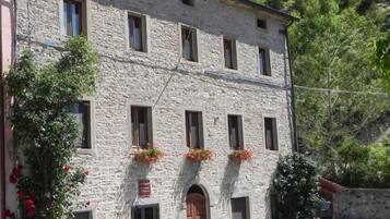Traditional stone building with a central entrance and evenly spaced windows.