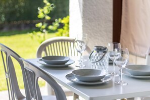 A dining table set with plates, glasses, and a pitcher, with chairs around it. - Oasis of Ticino Switzerland (Magliaso)