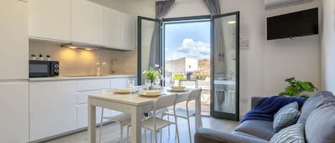 Un appartement moderne comprenant une cuisine, un coin repas et un salon.