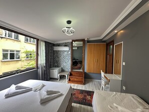 Ett modernt hotellrum med en stor säng, ett skrivbord, en garderob och utsikt över omgivningarna.