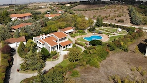 A residential area with houses, a swimming pool, and a mountainous backdrop. - Escape Villa in Melissochori (Oraiokastro)