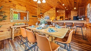 Un interno in legno con zona pranzo, sgabelli da bar e cucina.