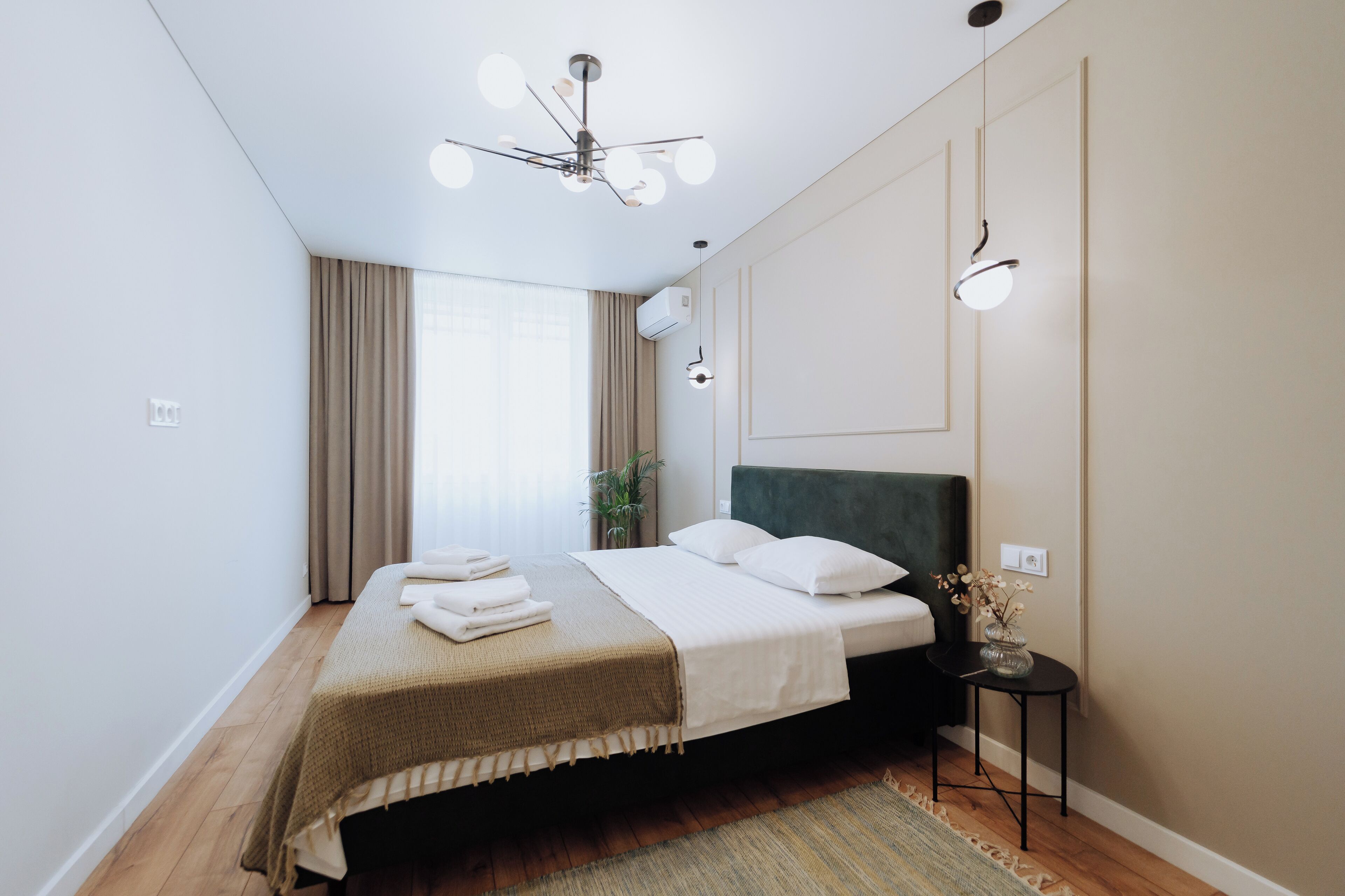 A modern bedroom with a bed, bedside table, and a ceiling fan.