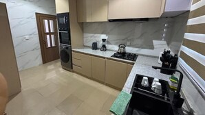 A compact kitchen with a microwave, oven, and coffee maker. - Ivorian Heaven Home (FCT)