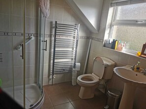 Ein Badezimmer mit Dusche, Toilette und Waschbecken.