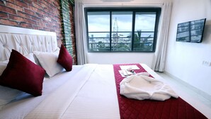 A hotel room with a bed, a red quilted bed runner, and a window with a city view. - 1 BHK Private Suite ( Gagal Home) (Mumbai)