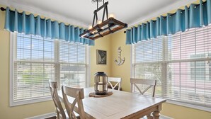 A dining area with a wooden table, chairs, and a chandelier.