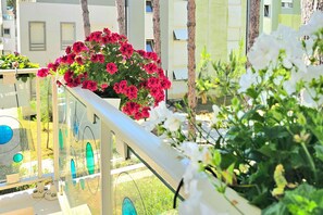 A balcony with a railing, potted plants, and a view of buildings. - Perla Resort Holiday Homes (Ishëm)