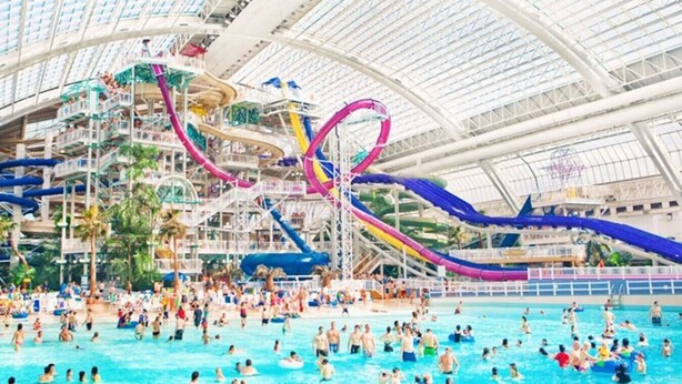 A large indoor water park with multiple slides and pools. - Pretty in Pink | Hot Tub | 10 min to WEM | KingBed (Edmonton)