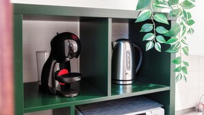 A kitchenette with a coffee maker, a kettle, and a potted plant. - Vinorum Studio (Massagno)