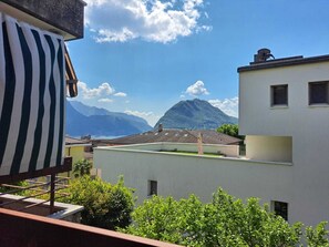 Un balcon avec vue sur la montagne et la mer.