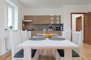Appartement | Privékeuken | Een koelkast, een magnetron, een kookplaat, kookgerei, borden en bestek