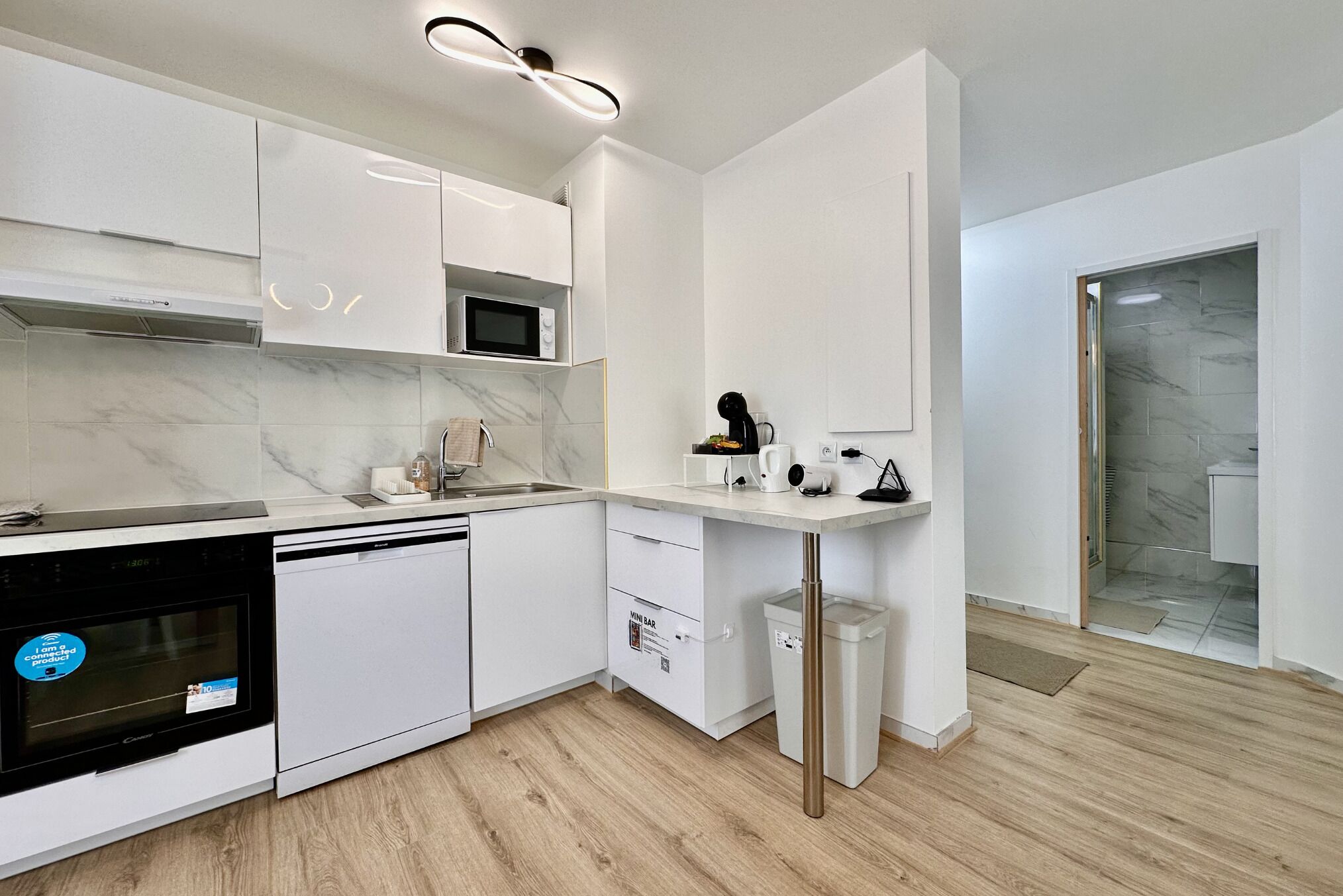 A modern kitchen with white cabinetry, a built-in microwave, and a dishwasher.