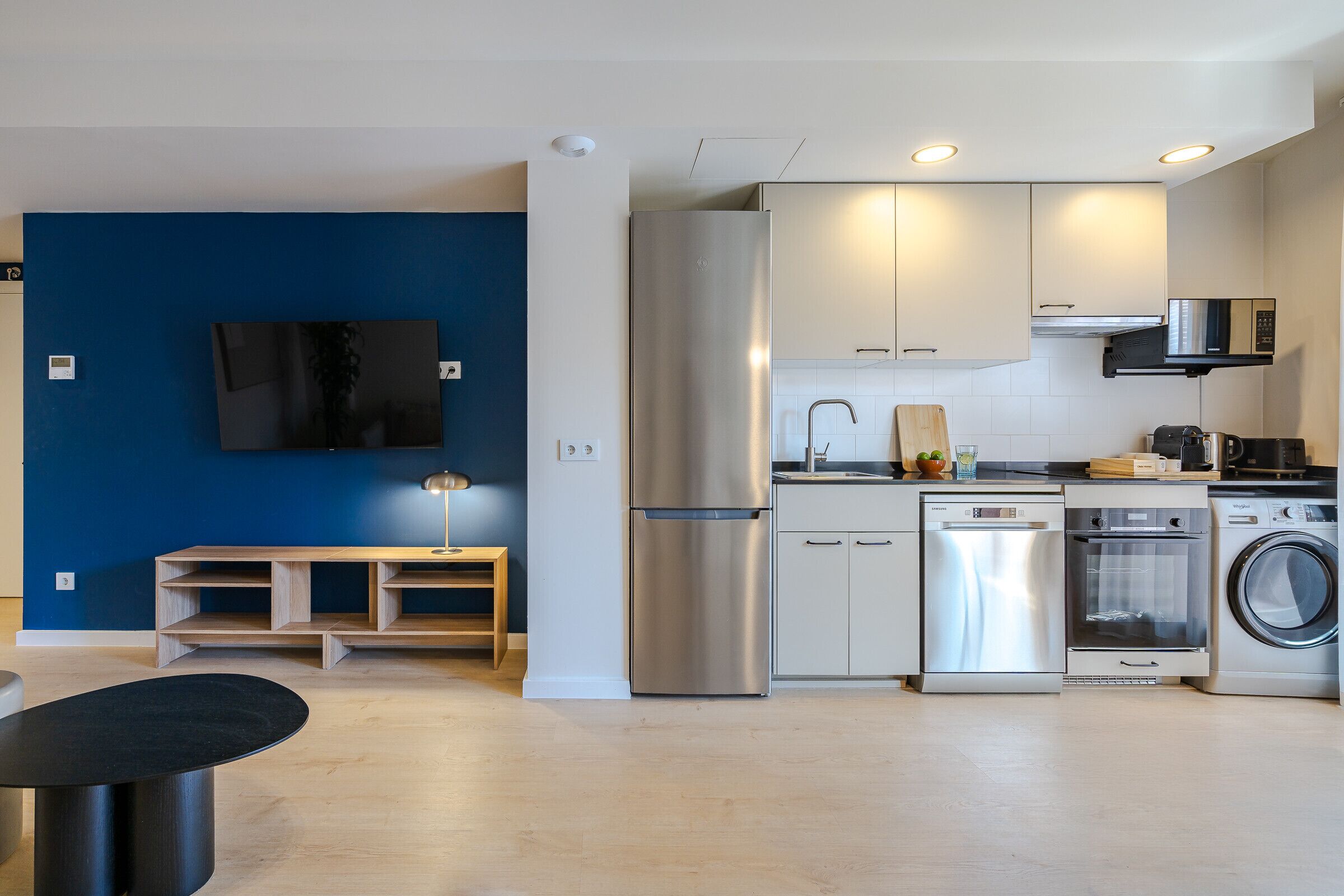 A modern kitchen with stainless steel appliances, a dishwasher, and a washing machine.
