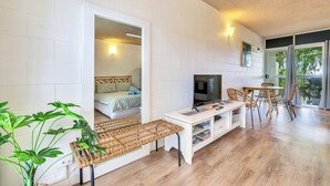 A room with a bed, a desk, a TV, and a dining area. - Self contained studio apartment overlooking the beautiful Nightcliff foreshore with your own private balcony. (Nightcliff)
