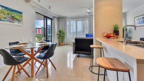 A modern apartment with a dining area, kitchen, and living space. - Waterfront Pearl Suite: 2 Bed Luxury Apt by Tropical BNB (Darwin City)
