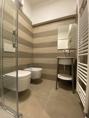 Chuveiro, secador de cabelo, bidê, toalhas de banho