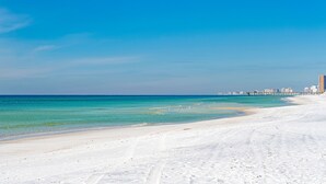 Une plage de sable blanc bordée d’une eau d’un bleu cristallin.