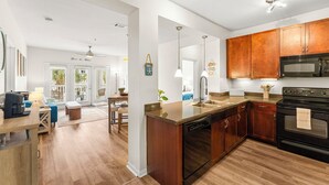 Une cuisine moderne avec des meubles en bois, une cuisinière noire et un lave-vaisselle.