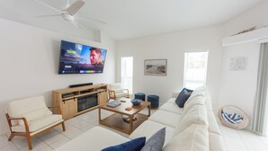 Una sala moderna con sofá, mesa de centro y televisor.