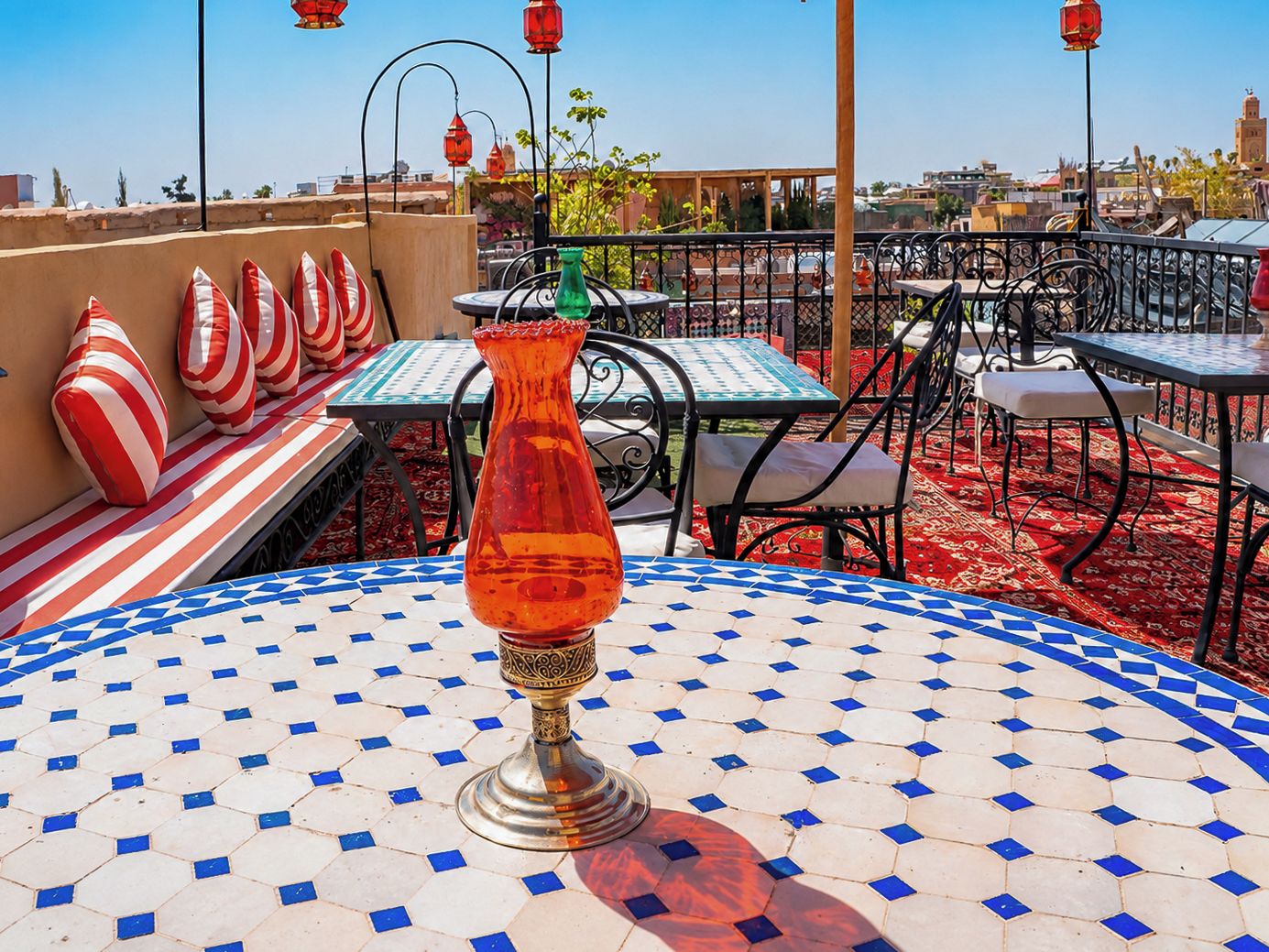 A terrace with outdoor seating, a decorative glass vase, and a patterned floor.
