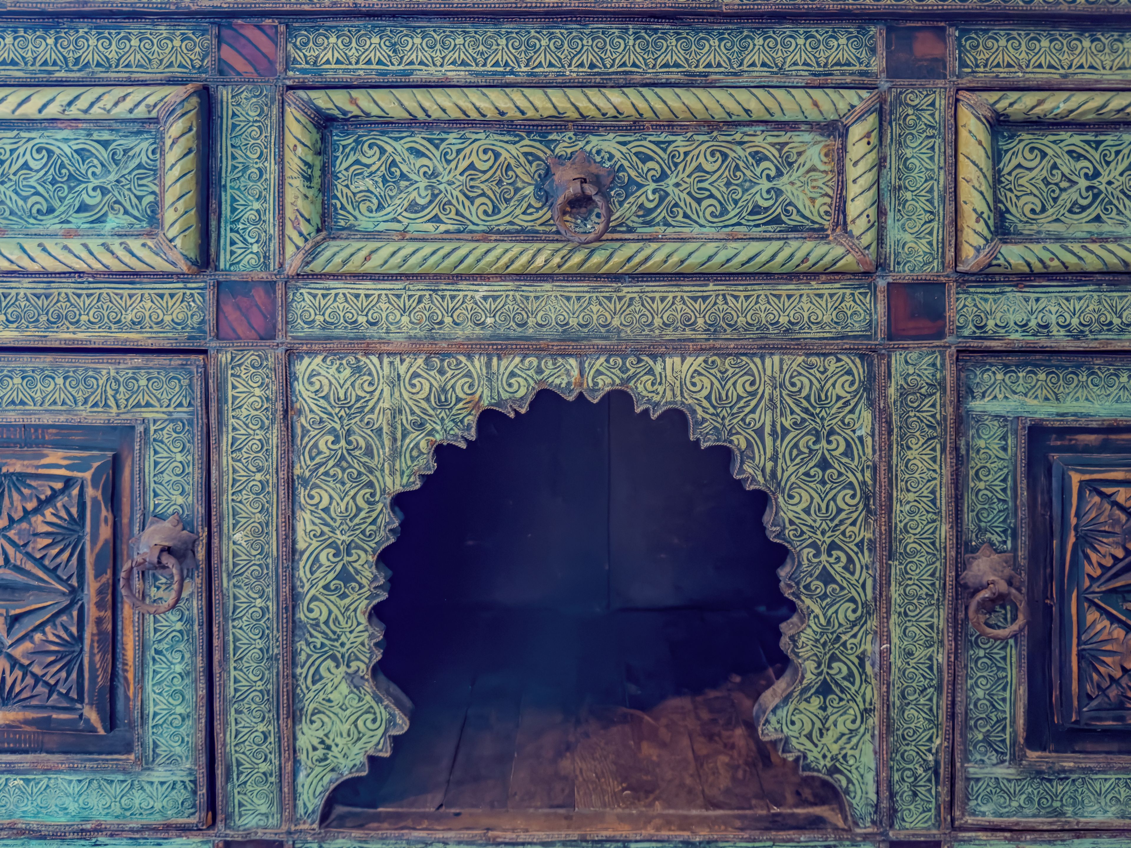 A detailed architectural facade with ornate patterns and a central archway.
