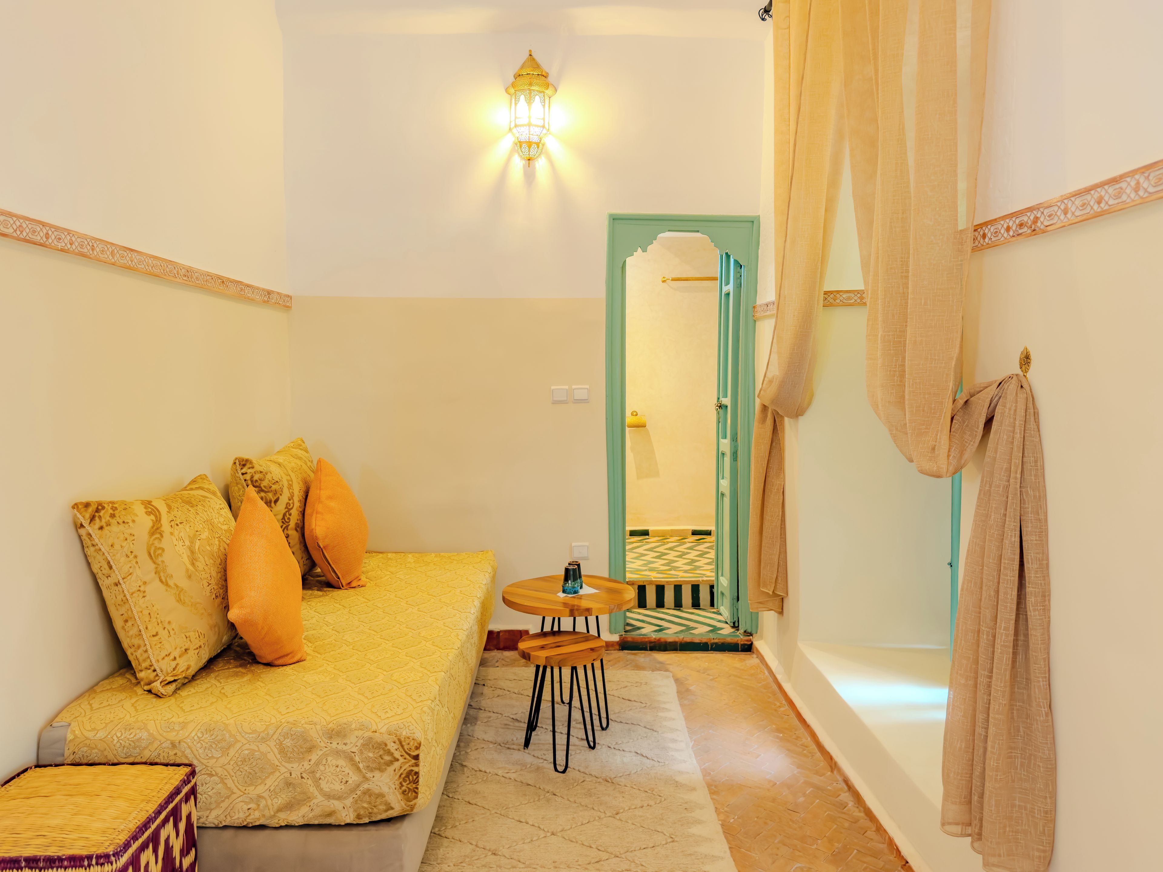 Una habitación acogedora con una cama, una mesita y un espejo.