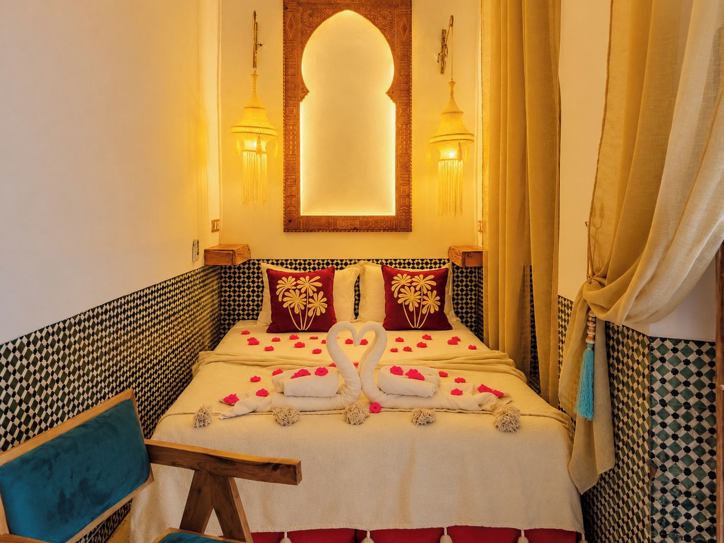 A hotel room with a bed, a chair, and a decorative wall.