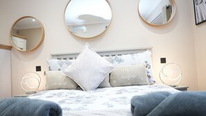 A bedroom with a bed, three wall mirrors, and two bedside lamps. - Charming London House - Sleeps 4 & Outdoor Space (London)