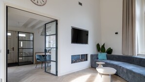 Un salon moderne comprenant un canapé, un téléviseur, une cheminée et un coin repas.