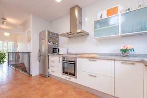 Una cocina moderna con armarios blancos, electrodomésticos de acero inoxidable y salpicadero de azulejos.