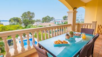 Enjoy a refreshing morning on the balcony with a clear view of the pool and lush surroundings.