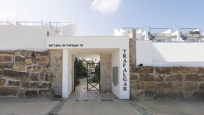 En steninramad entré med en metallgrind, där det står ”Av/Cabo de Trafalgar 10” och ”TRAFALGAR” på väggen.