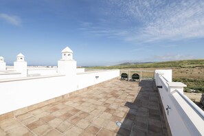 A rooftop terrace with a clear view of the landscape, white walls, and a tiled floor. - Trafalgar Sunset Home (Tarifa)