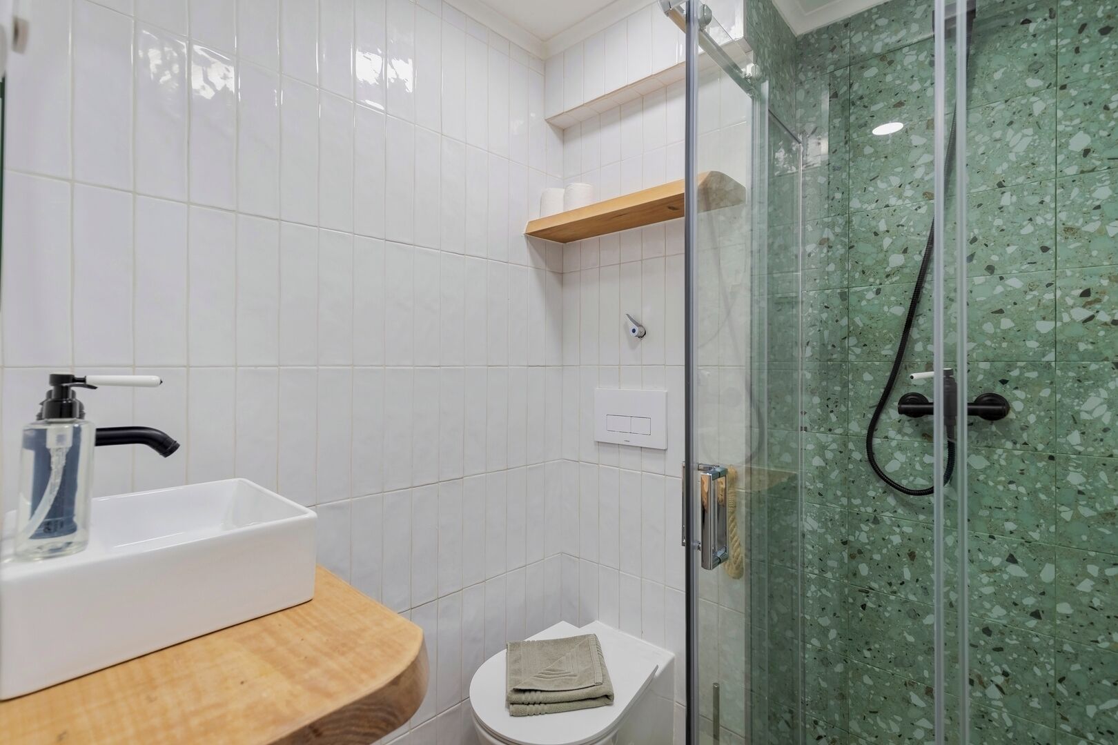 A bathroom with a white sink, a glass shower enclosure, and a toilet.