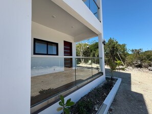 Un edificio moderno con grandes ventanales, un balcón y vistas del paisaje circundante.