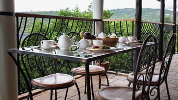 Enjoy a meal on the outdoor space with a table set for two, featuring a teapot, cups, and a bread basket.