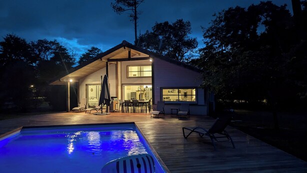 A two-story house with a swimming pool, outdoor seating, and a large window overlooking the pool. - Villa on the edge of the forest, beach and golf course nearby. Ideal for families! (Moliets-et-Maa)