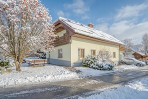 Una casa de dos pisos con techo nevado y un balcón.